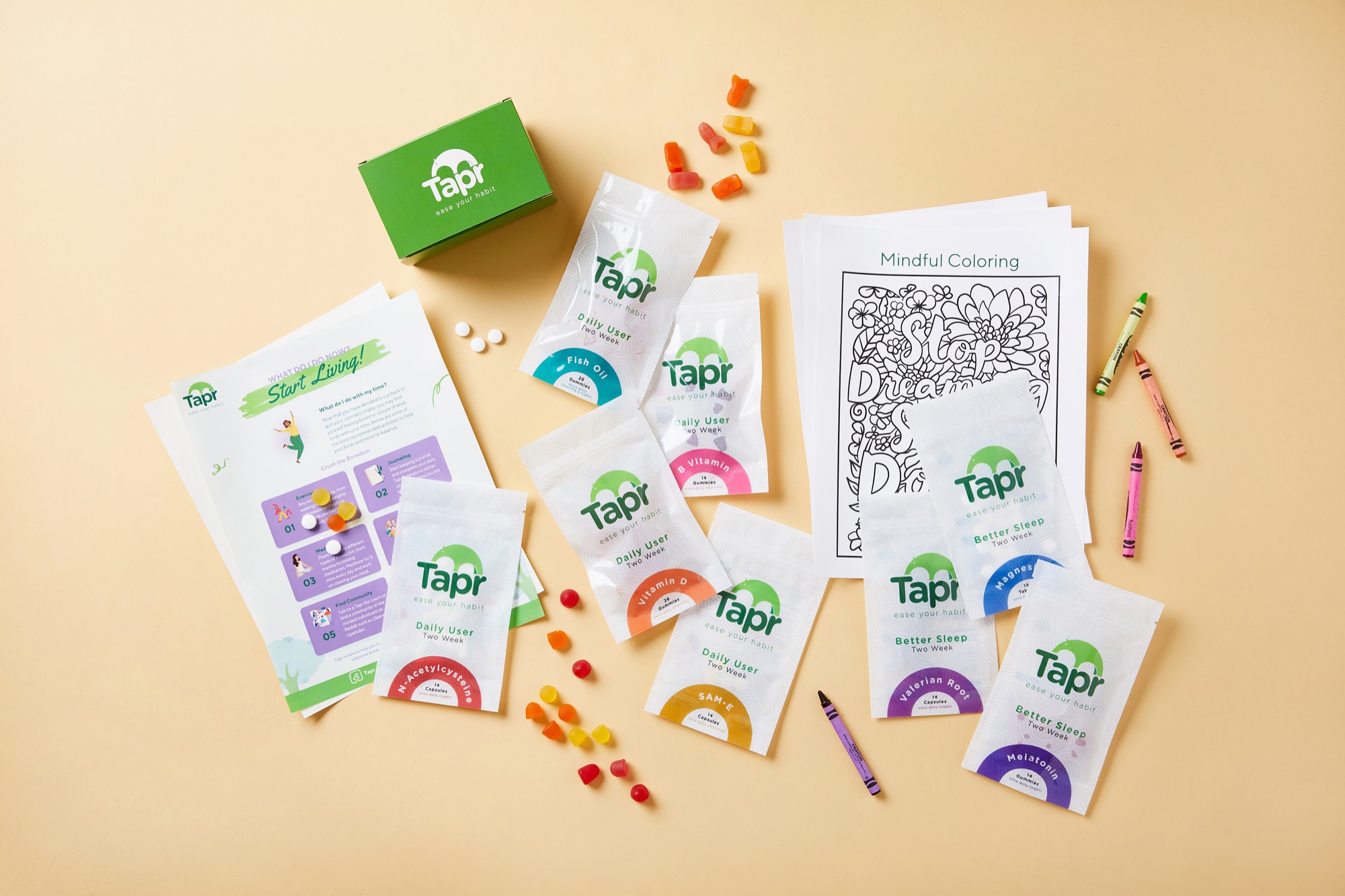 A Tapr box laid out — Daily User and Better Sleep supplements, chamomile tea, gummies, and mindful-coloring pages